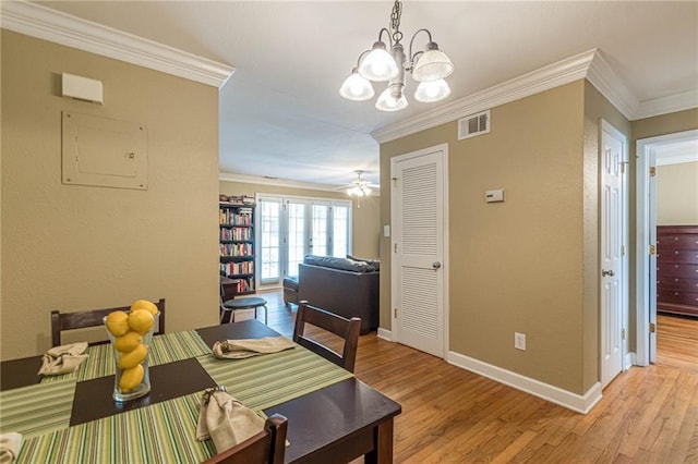 dining space with ceiling fan with notable chandelier, french doors, light wood-type flooring, and crown molding