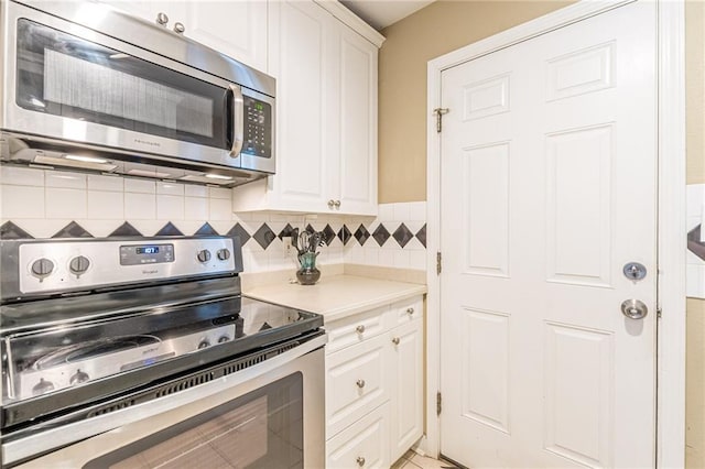 kitchen featuring backsplash, white cabinets, and appliances with stainless steel finishes