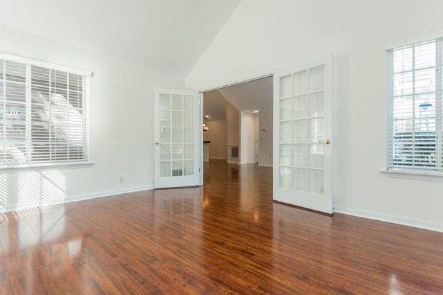 empty room with wood finished floors, visible vents, baseboards, high vaulted ceiling, and french doors