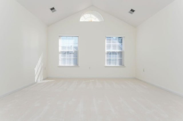 carpeted empty room with visible vents and lofted ceiling