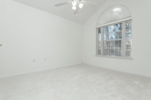 empty room featuring vaulted ceiling, carpet, baseboards, and ceiling fan