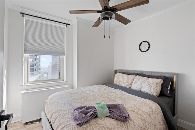 bedroom with ceiling fan, ornamental molding, and light hardwood / wood-style floors