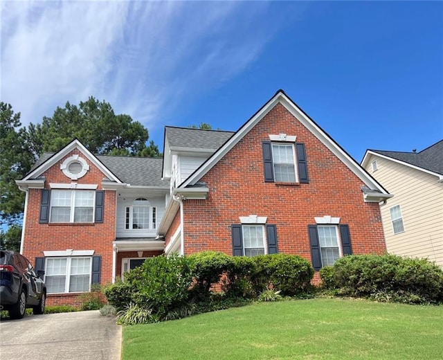 traditional-style home with brick siding and a front yard