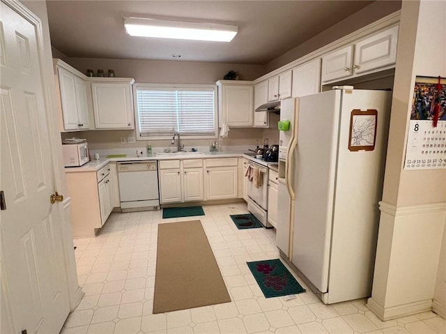 kitchen featuring light floors, a sink, light countertops, and white appliances
