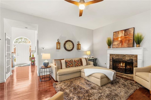 living room featuring wood finished floors, ceiling fan, and a fireplace