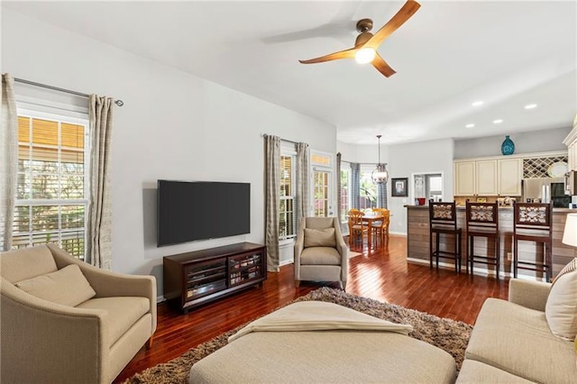 living area with a ceiling fan, wood finished floors, recessed lighting, and baseboards