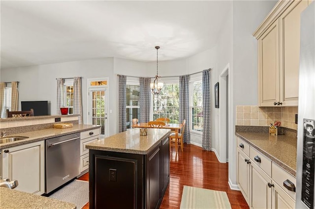 kitchen featuring appliances with stainless steel finishes, cream cabinets, a chandelier, and dark wood-style flooring