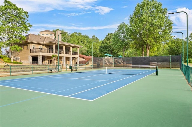 view of tennis court with fence and community basketball court