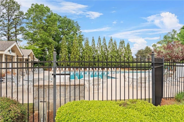 community pool with fence and a patio area