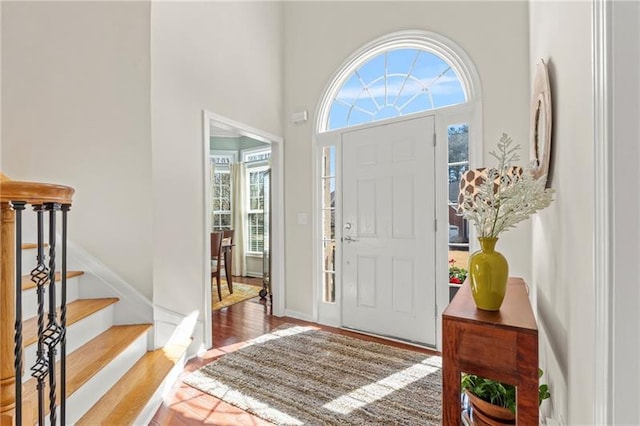 entryway with wood finished floors and stairs
