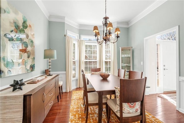 dining area with a chandelier, plenty of natural light, wood finished floors, and ornamental molding