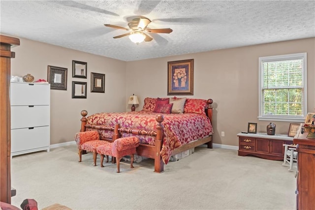 bedroom with a textured ceiling, light carpet, baseboards, and a ceiling fan