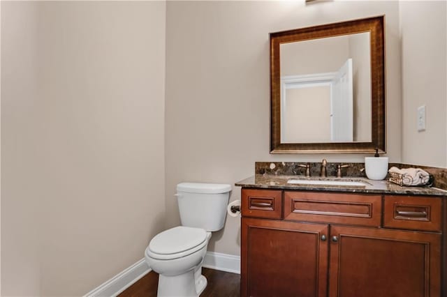 3920 Baverton Dr, Suwanee, GA 30024 - half bathroom featuring baseboards, toilet, vanity, and wood finished floors