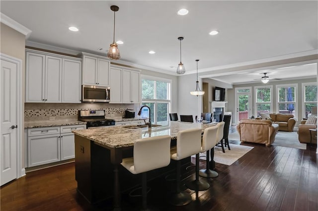 3920 Baverton Dr, Suwanee, GA 30024 - kitchen with stainless steel appliances, a sink, tasteful backsplash, ornamental molding, and light stone counters