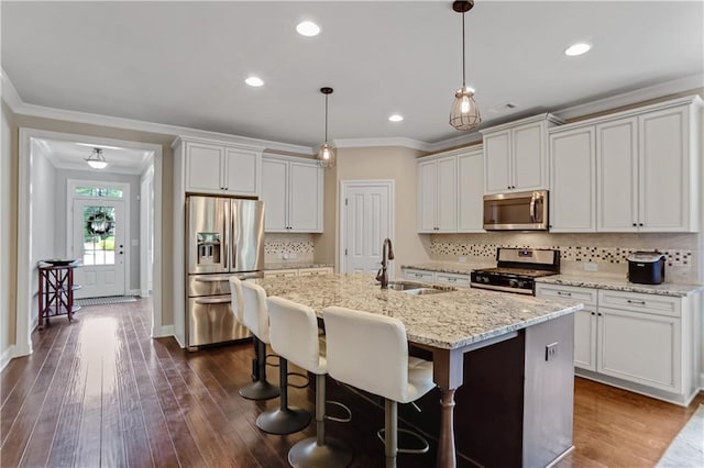 3920 Baverton Dr, Suwanee, GA 30024 - kitchen featuring stainless steel appliances, a sink, ornamental molding, backsplash, and a center island with sink