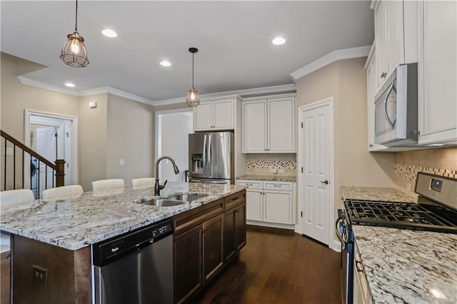 3920 Baverton Dr, Suwanee, GA 30024 - kitchen featuring appliances with stainless steel finishes, a sink, ornamental molding, dark wood-style flooring, and an island with sink