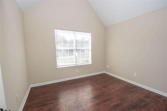 spare room featuring vaulted ceiling and dark hardwood / wood-style floors