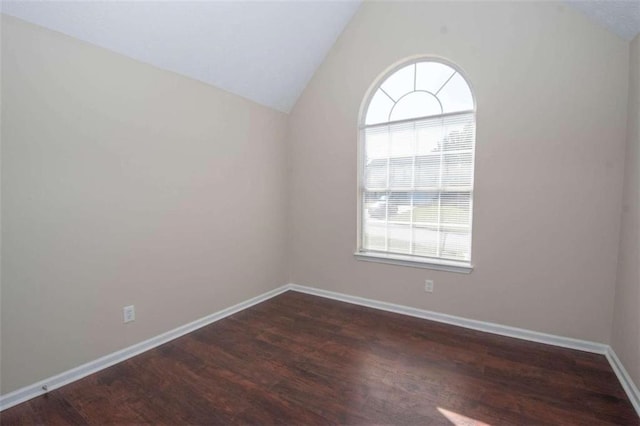 empty room with vaulted ceiling and dark wood-type flooring