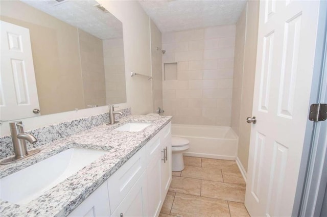 full bathroom featuring vanity, tiled shower / bath combo, toilet, and a textured ceiling