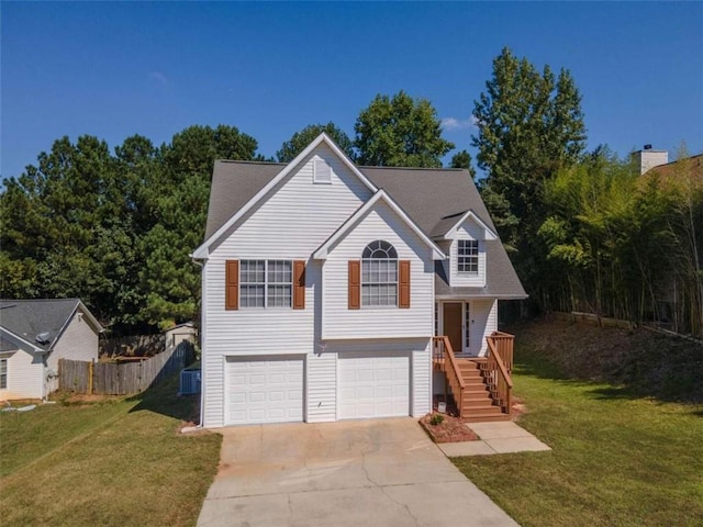 raised ranch featuring a garage, central AC unit, and a front lawn