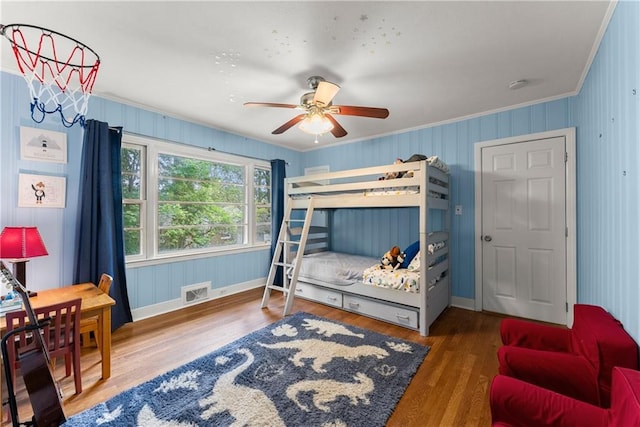 bedroom with crown molding, wood finished floors, baseboards, and ceiling fan