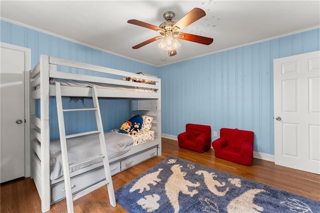 bedroom with crown molding, wood finished floors, ceiling fan, and baseboards