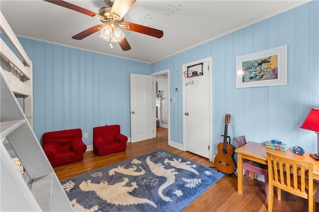 sitting room featuring crown molding, wood finished floors, and a ceiling fan