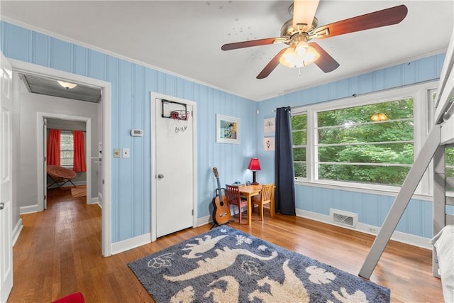 bedroom featuring ornamental molding, wood finished floors, baseboards, and ceiling fan