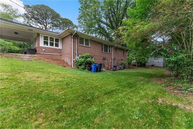 view of side of property featuring a lawn and brick siding
