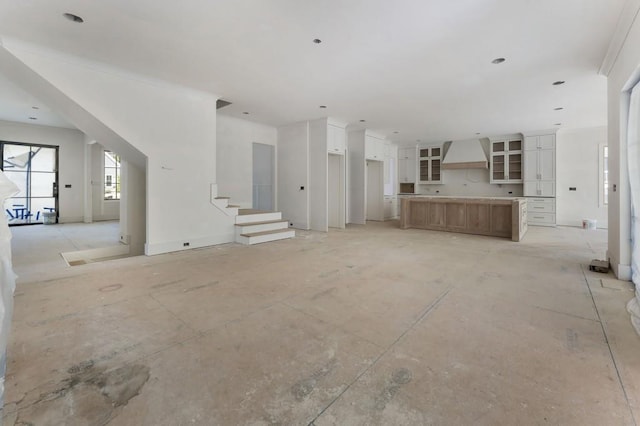unfurnished living room featuring stairway