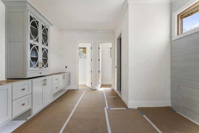 corridor with healthy amount of natural light and baseboards