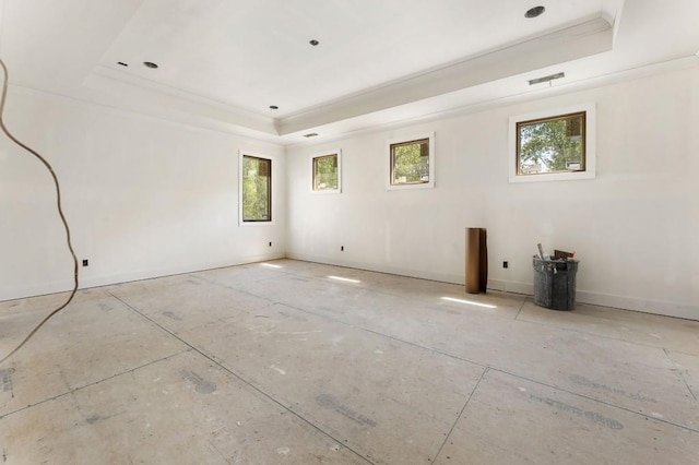 empty room with a raised ceiling, healthy amount of natural light, ornamental molding, and baseboards