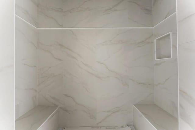 bathroom with a marble finish shower