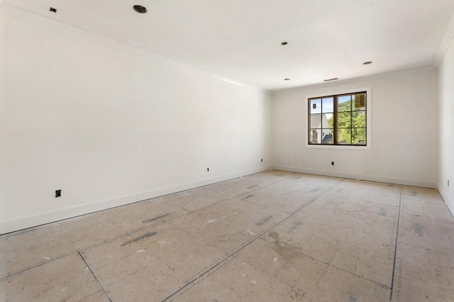 spare room with ornamental molding and baseboards