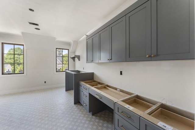 unfurnished office featuring healthy amount of natural light and baseboards