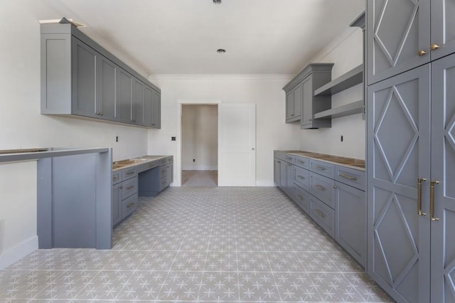 kitchen featuring light floors, gray cabinets, and baseboards