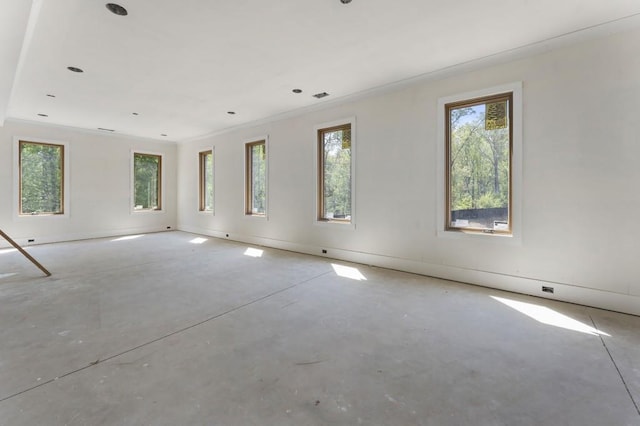 unfurnished room with healthy amount of natural light and unfinished concrete floors