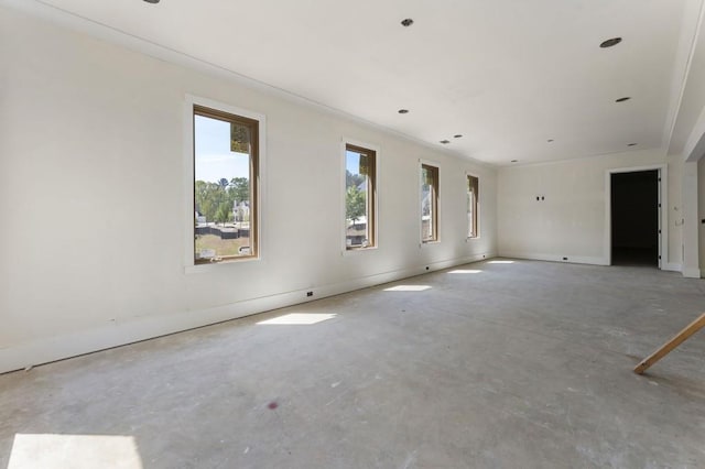 spare room with concrete flooring and baseboards
