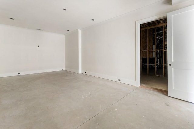 unfurnished room featuring concrete floors and baseboards