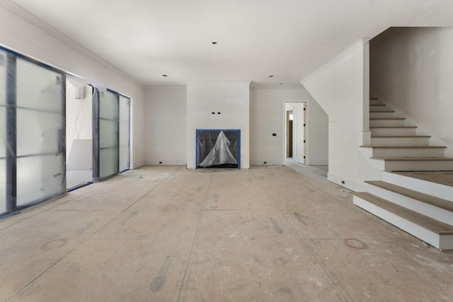 unfurnished living room with stairs