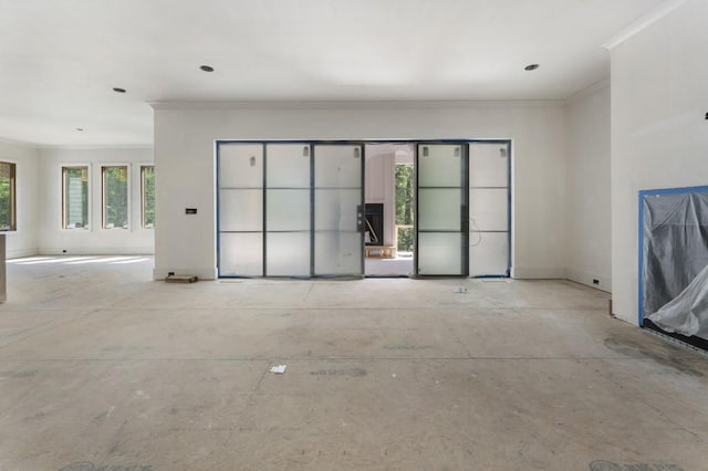 unfurnished living room with ornamental molding and baseboards
