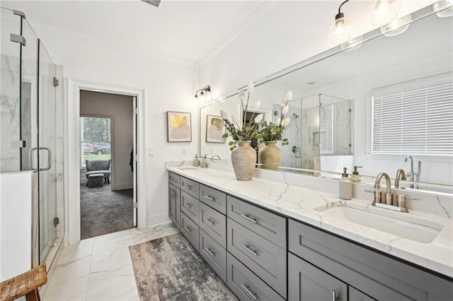 full bathroom with marble finish flooring, crown molding, double vanity, a shower stall, and baseboards