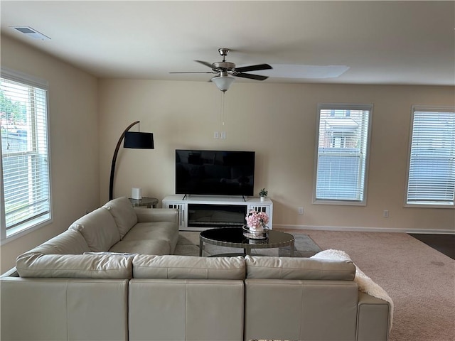 living room featuring ceiling fan, a healthy amount of sunlight, and carpet flooring