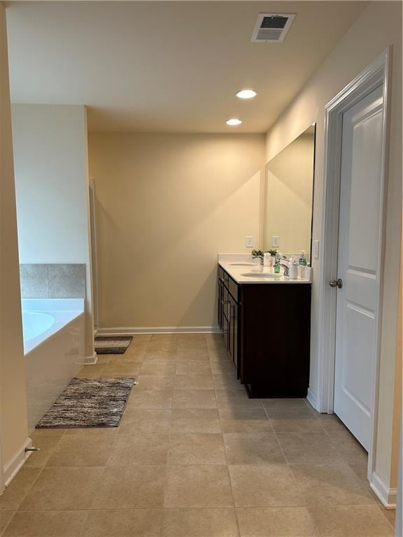 bathroom with a relaxing tiled tub and vanity