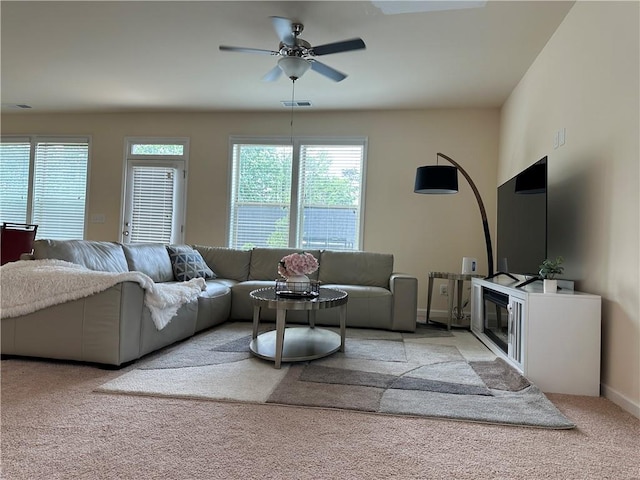 carpeted living room with ceiling fan