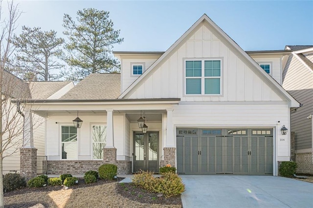 view of front facade with a porch, board and batten siding, driveway, and a garage