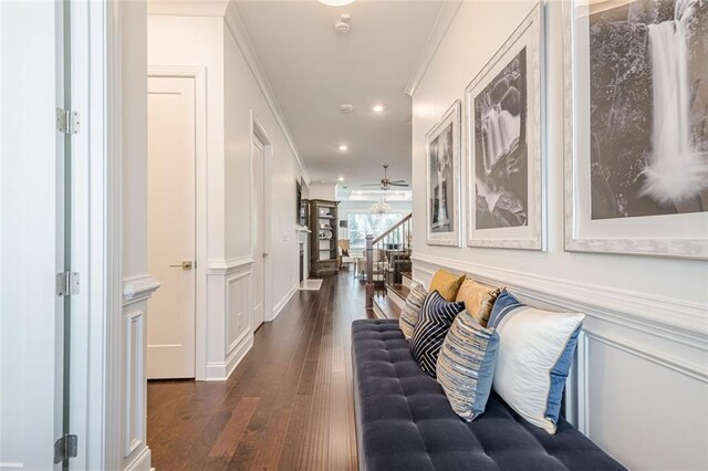 interior space with a decorative wall, plenty of natural light, crown molding, and dark wood-style flooring