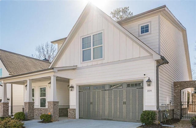 view of front of house featuring a porch, fence, board and batten siding, concrete driveway, and a garage