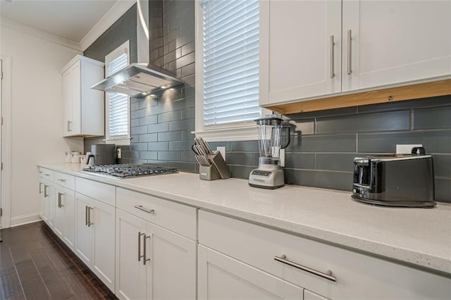 kitchen featuring dark wood-style flooring, a sink, ornamental molding, appliances with stainless steel finishes, and a glass covered fireplace
