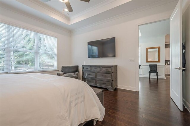 bedroom featuring a tray ceiling, visible vents, and wood finished floors